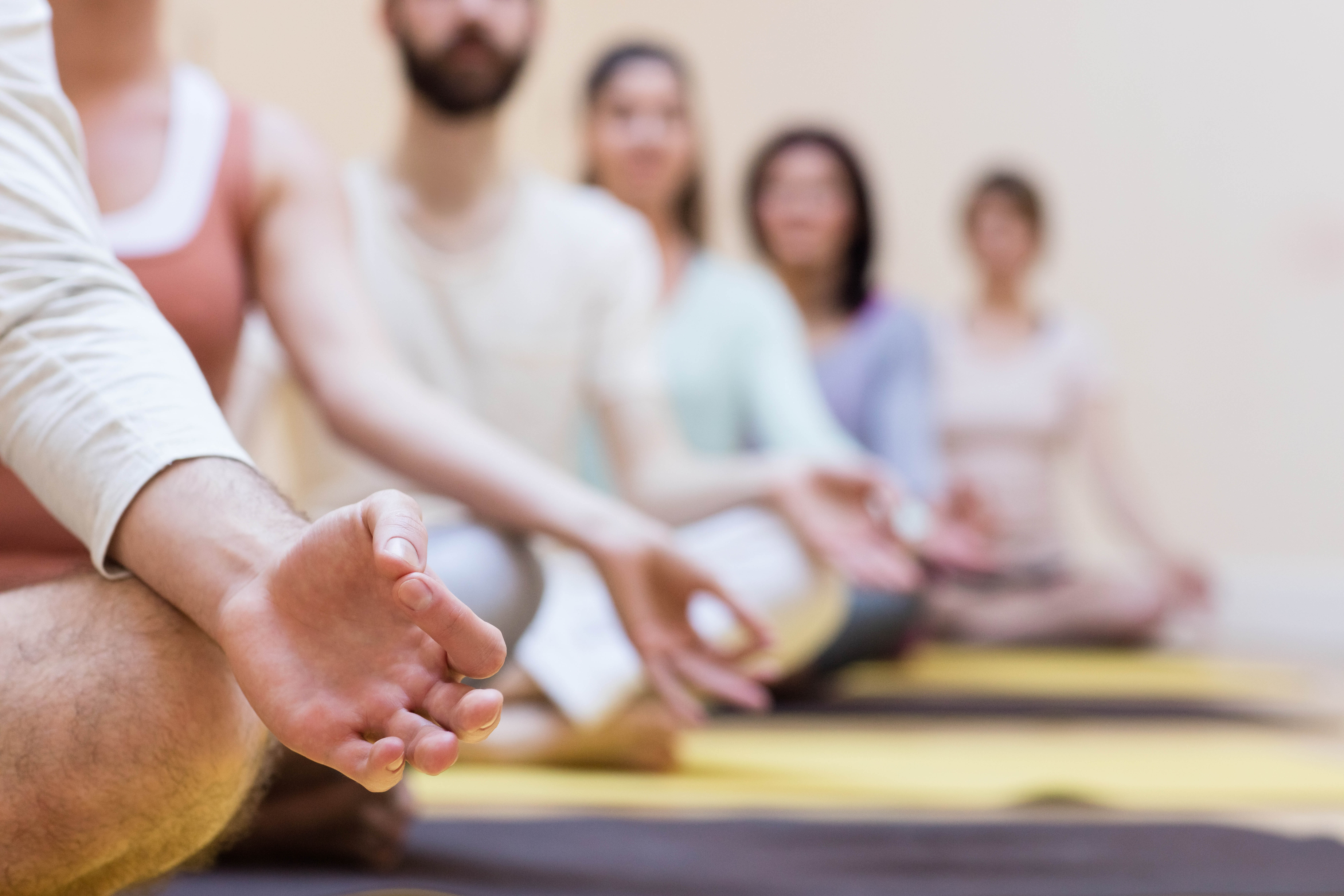 Group of people doing meditation on exercise mat